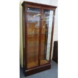 An early 20th century mahogany shop display cabinet with pair of glazed doors enclosing adjustable