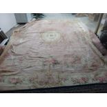 A large Austrian carpet, the plain pink field with an ivory roundel, floral spandrels,
