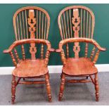 A pair of early Victorian style ash and elm Windsor chairs, with solid seats and turned supports,