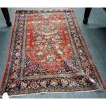 A Kashan rug, Persian, the madder field with a vase filled with abundant floral sprays,