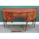 A George III mahogany semi elliptic sideboard with four frieze drawers flanked by cupboards on
