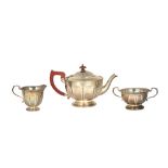 A silver three piece tea set, comprising; a teapot, a twin handled sugar bowl and a milk jug,