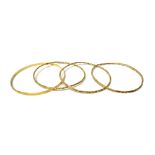 Three gold circular bangles, detailed 750 and another gold circular bangle,