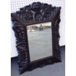 A late 19th century Dutch wall mirror, the carved oak swept frame with lion face mask,