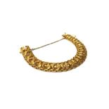 A gold bracelet, pierced in a multiple link design, with engraved decoration, on a snap clasp,