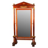 An empire ormolu mounted mahogany cheval mirror with architectural cornice and turned columns on