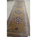 A Bidjar runner, Persian, the plain brown field with five dark indigo herate pattern medallions,