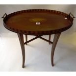 An Edwardian inlaid mahogany oval tray, on four splayed supports, 57cm wide x 54cm high x 38cm deep.