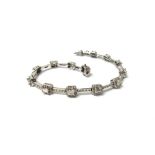 An 18ct white gold and diamond bracelet, formed as a series of cut cornered square clusters,