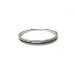 A white gold, sapphire and diamond set oval hinged bangle,