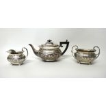 A late Victorian silver three piece tea set, comprising; a teapot,