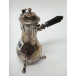 A French hinge lidded small hot milk jug, of baluster form, raised on three feet,