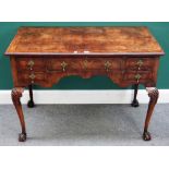 A George II style figured walnut lowboy with five frieze drawers on claw and ball feet,