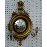 A small 19th century gilt framed convex wall mirror, with twin candle sconce, 40cm wide x 68cm high.