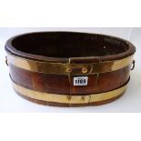An oval coopered copper bound planter, with ring handles, 40cm wide x 13cm high x 25cm deep.