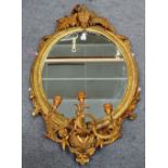 A Victorian gilt framed three branch girandole wall mirror with fern moulded crest and oval plate,