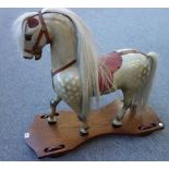 A child's dapple grey ride-on horse, 20th century, with leather saddlery,
