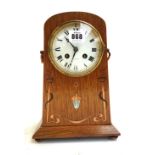 An oak Arts and Crafts mantel clock, with copper and mother-of-pearl inlay,