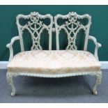 A Chippendale Revival gold and cream painted double chair back sofa, on scroll supports,