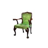 A George II style walnut framed open armchair, with lion's head finials, on ball and claw feet,