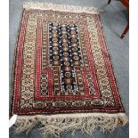 A Beluchistan prayer rug, with black flower mehrab and hooked medallion border, 136cm x 96cm.