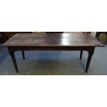 An 18th century oak kitchen table, with cleated plank top, on turned supports,