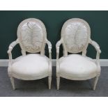 A pair of white painted Louis XVI style armchairs with bow seats on tapering fluted supports,