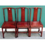 A set of three 20th century Chinese hardwood yoke back dining chairs,