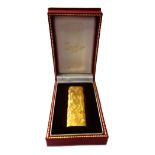 Cartier; a gold plated lighter, with textured finish, signed, numbered 177350, 7cm long, cased.