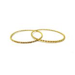 A pair of Middle Eastern gold circular bangles, each in a faceted ropetwist wirework design,