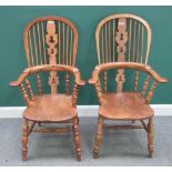 A pair of early Victorian style ash and elm Windsor chairs, with solid seats and turned supports,