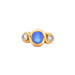 An 18ct gold, cabochon sapphire and diamond set three stone ring, by Annabel Jones,