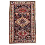 A Shirvan rug, Caucasian, the black field with an ivory and two madder stepped diamonds,