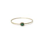 A gold, emerald and diamond set oval cluster bangle, of sprung form,