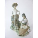 A large Lladro group modelled as a boy and girl with lamb,