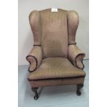 An early 20c winged armchair upholstered in purple and gold material clean condition est: £200-£400