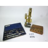 An antique brass microscope; a boxed set