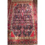 A 20c Persian rug on red ground (1.84 x