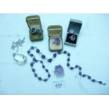 A collection of five various amethyst rings, an amethyst & crystal necklace,