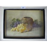 A framed and glazed watercolour still life study of grapes by a vase signed indistinctly lower