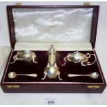 A silver condiment set comprising salt, pepper, mustard,