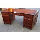 A large Chinese possibly Huanghuali wood desk with a centre drawer flanked either side by cupboards