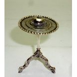 A small possibly silver tripod table eng