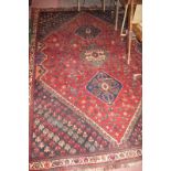 A mid 20c Persian rug on Burgundy ground with three central medallions (250 x 172 cm approx) est:
