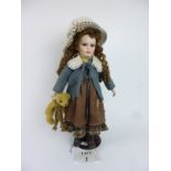 A decorative porcelain and cloth doll with chestnut brown hair est: £15-£30 (A1)