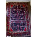 A 20c Persian rug on red ground (1.84 x 1.