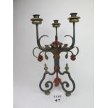 A large, painted cast iron three branch candelabra with rose motifs and decoration,