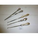 A pair of silver handled glove stretchers Chester 1903 and three button hooks (two fully