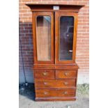An Edwardian mahogany bookcase with two shelves over two small drawers cupboards and two long