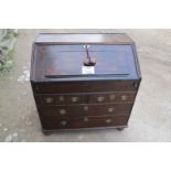 A Queen Anne oak bureau with a fitted interior and well over two short and two long drawers,